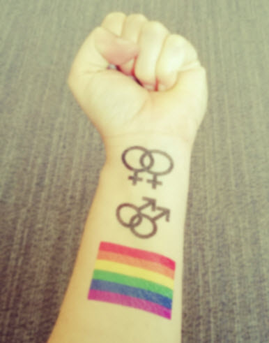 Premium Photo  Vibrant shot of arm in fist with rainbow flag tattoo as  power symbol for pride month lgbtq